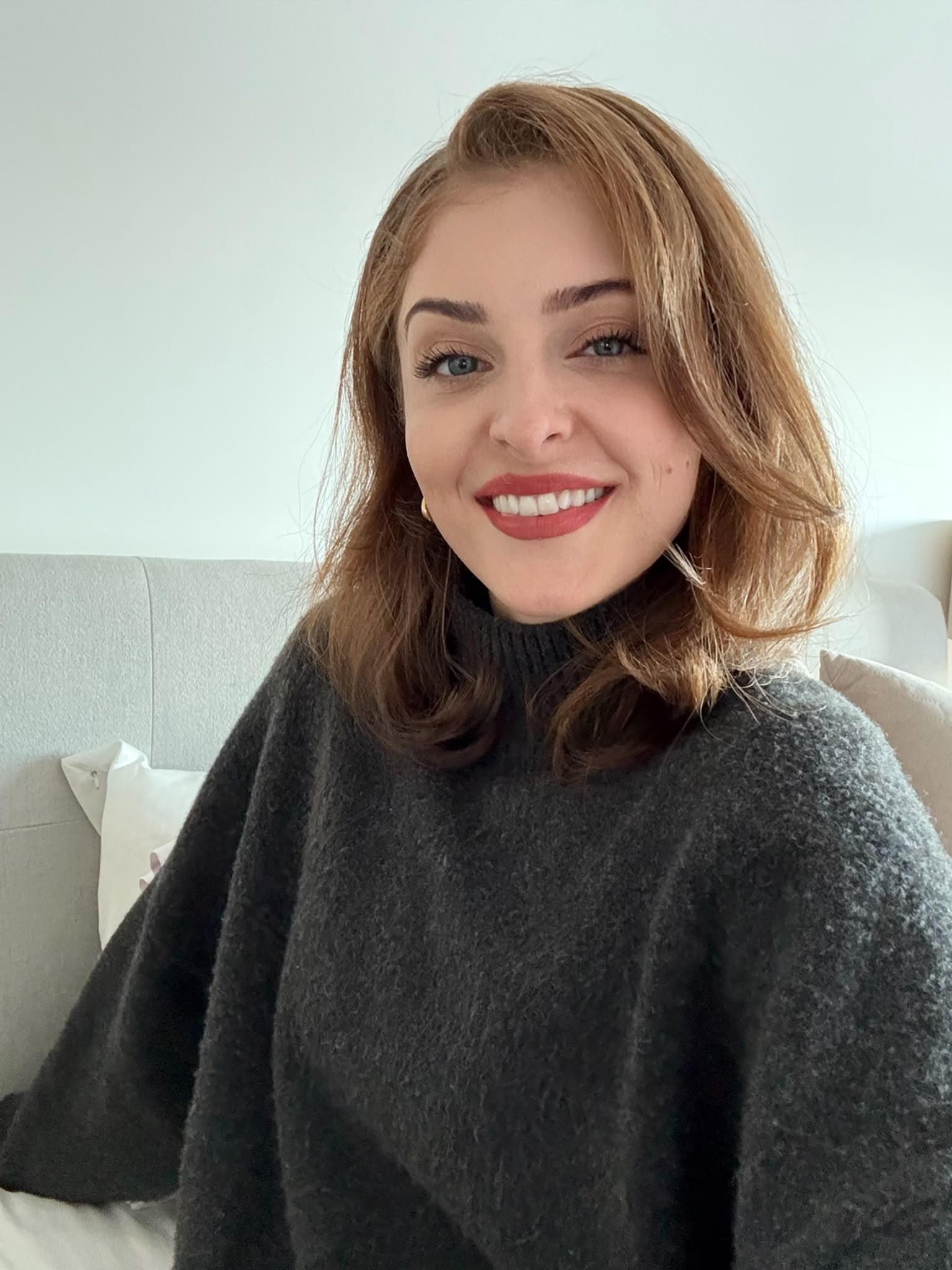 Laura, smiling, in a dark jumper
