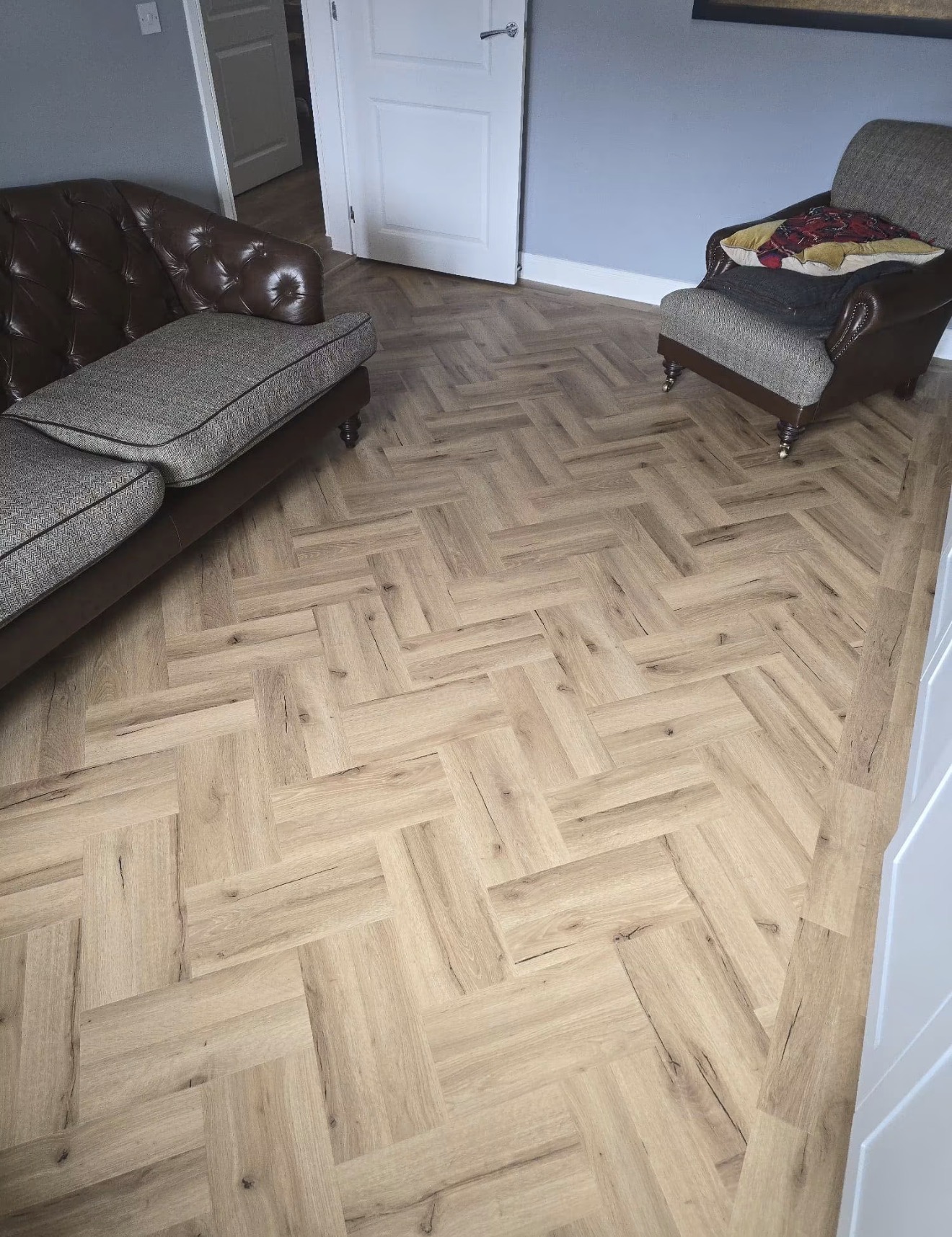 Finished herringbone flooring in a furnished living room
