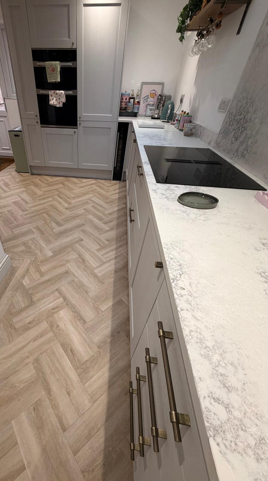 Full view of a finished kitchen with pale herringbone LVT