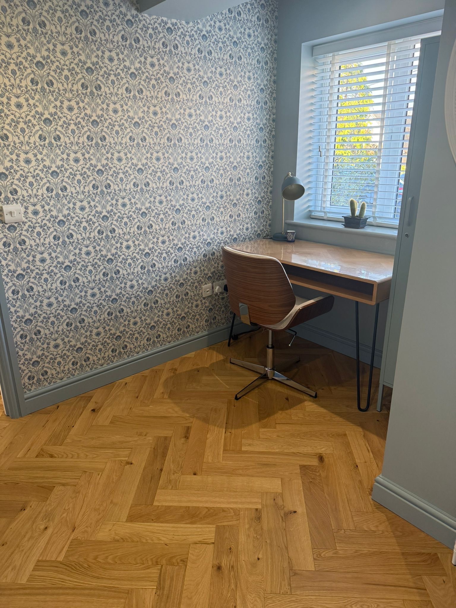 Herringbone study with blue wallpaper